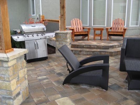 This is an example of a medium sized classic back patio in Kansas City with an outdoor kitchen, concrete paving and a pergola.