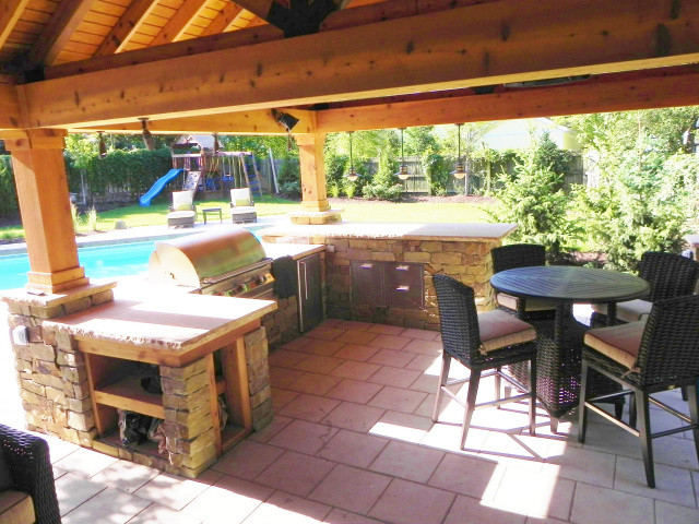 Modelo de patio tradicional de tamaño medio en patio trasero con cocina exterior, suelo de baldosas y pérgola