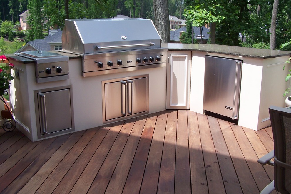 Example of a mid-sized classic backyard stone patio kitchen design in DC Metro with no cover