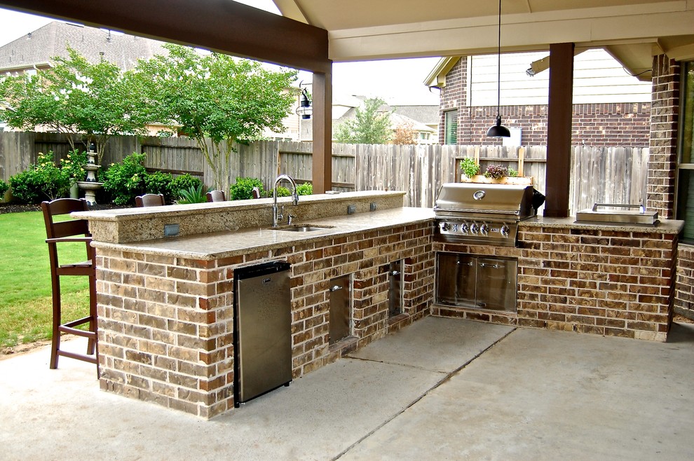 Medium sized traditional back patio in Houston with an outdoor kitchen and a roof extension.