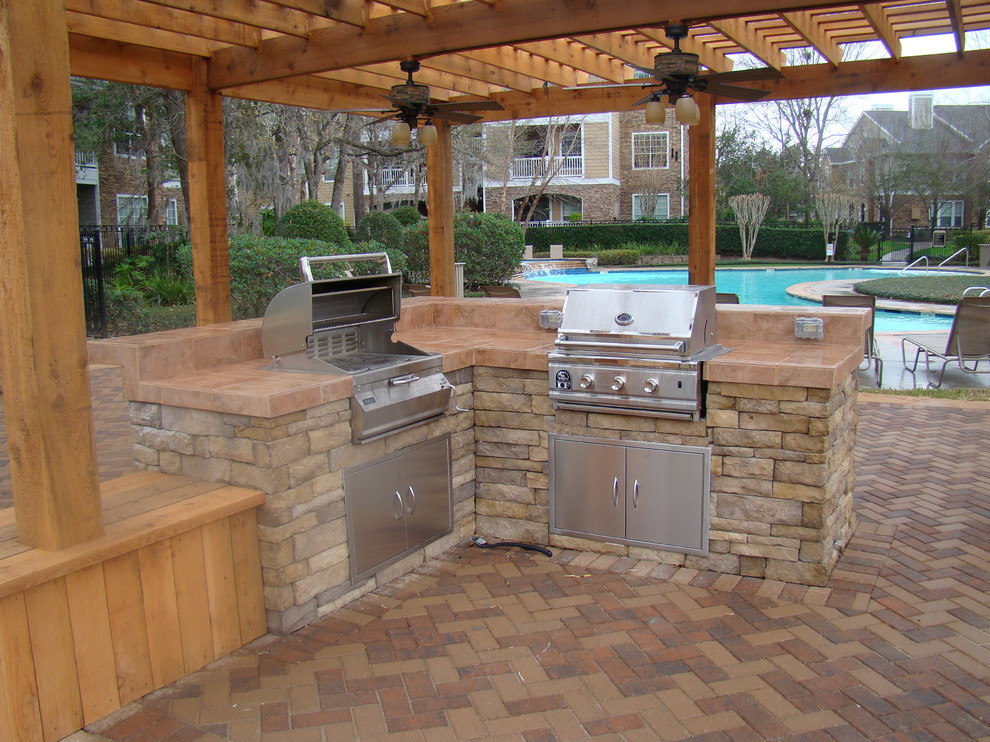 Idées déco pour une terrasse classique avec une cuisine d'été, une cour, des pavés en brique et une extension de toiture.