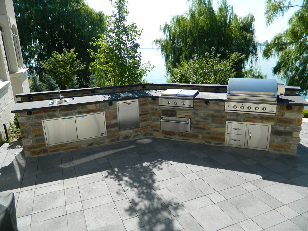 Cette image montre une terrasse arrière traditionnelle de taille moyenne avec une cuisine d'été, des pavés en béton et aucune couverture.