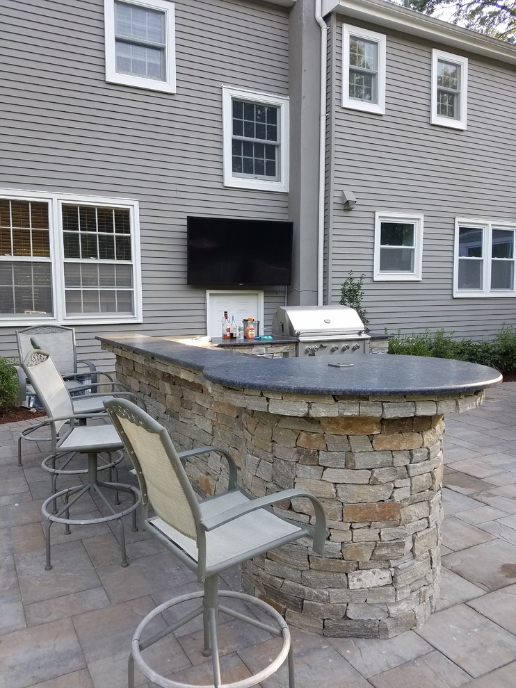 Photo of a back patio in New York with an outdoor kitchen.