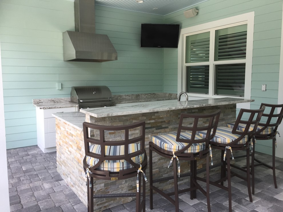 Inspiration for a large contemporary back patio in Tampa with an outdoor kitchen and a roof extension.