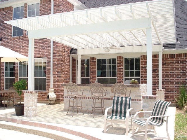 Design ideas for a contemporary back patio in Houston with an outdoor kitchen, concrete slabs and a pergola.