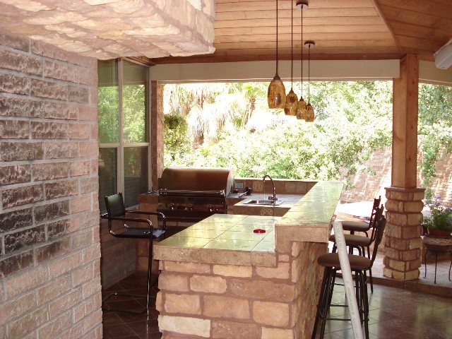 Überdachter Moderner Patio hinter dem Haus mit Outdoor-Küche und Betonplatten in Houston