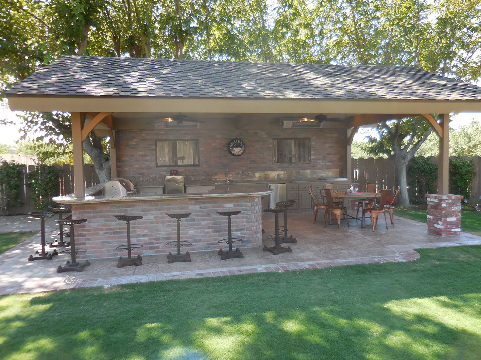 Ejemplo de patio rústico grande en patio trasero con cocina exterior, suelo de hormigón estampado y pérgola