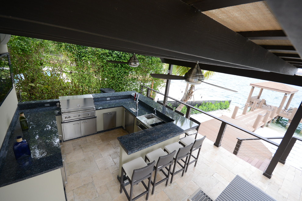 Immagine di un ampio patio o portico minimalista dietro casa con pavimentazioni in pietra naturale e una pergola