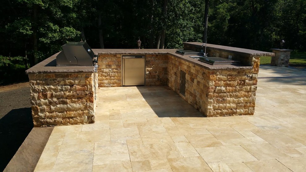 Foto de patio clásico de tamaño medio sin cubierta en patio trasero con cocina exterior y adoquines de piedra natural