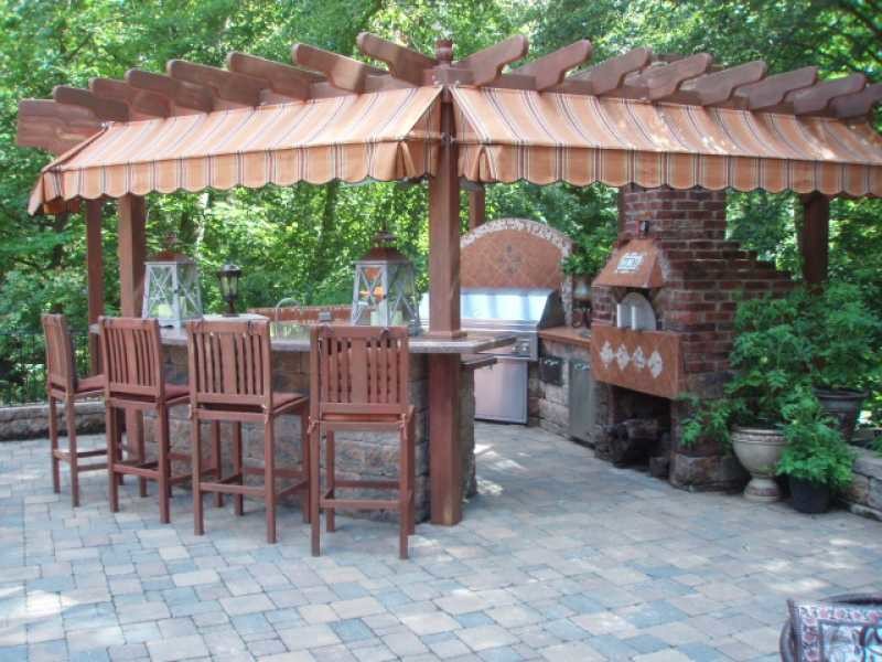 Design ideas for a large classic back patio in New York with an outdoor kitchen, brick paving and a pergola.