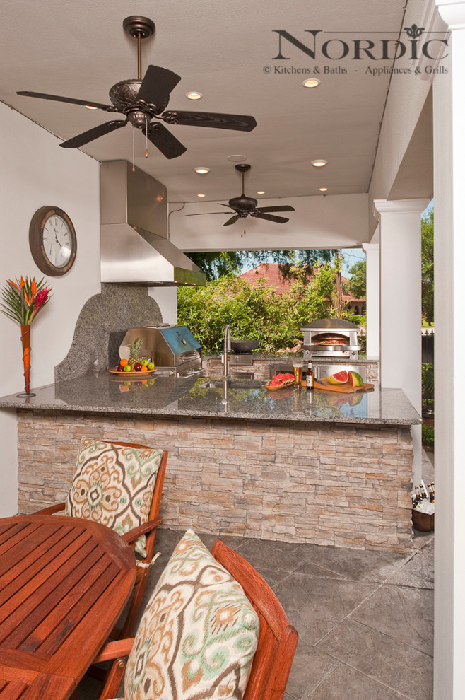 Imagen de patio tradicional grande en patio trasero y anexo de casas con cocina exterior y adoquines de piedra natural