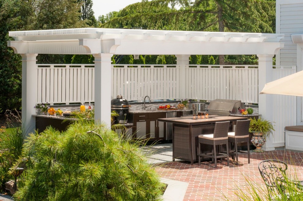 Design ideas for a large contemporary back patio in New York with an outdoor kitchen, brick paving and an awning.