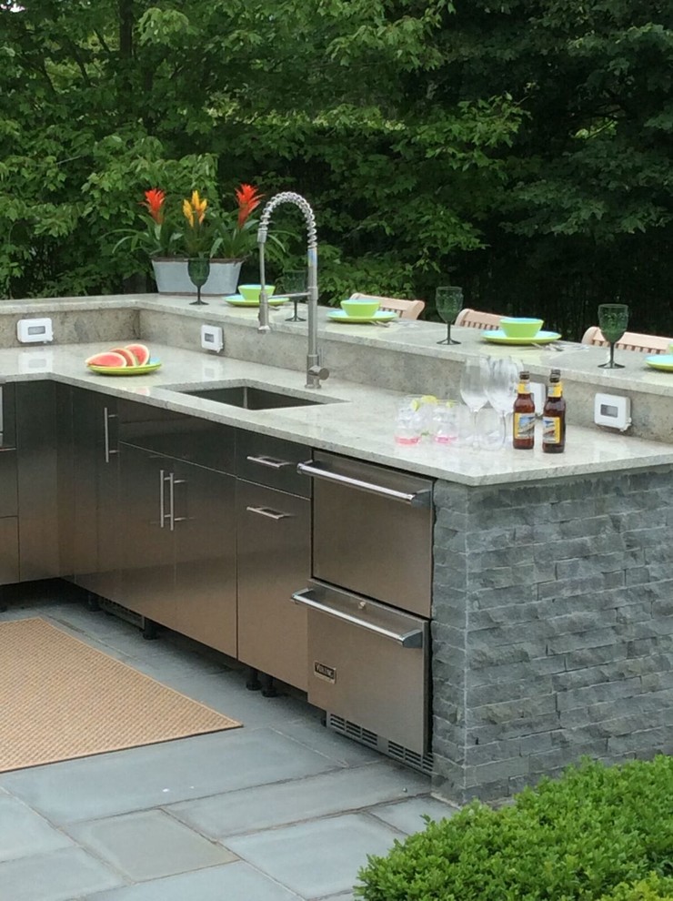 Patio kitchen - large traditional backyard concrete paver patio kitchen idea in New York with an awning