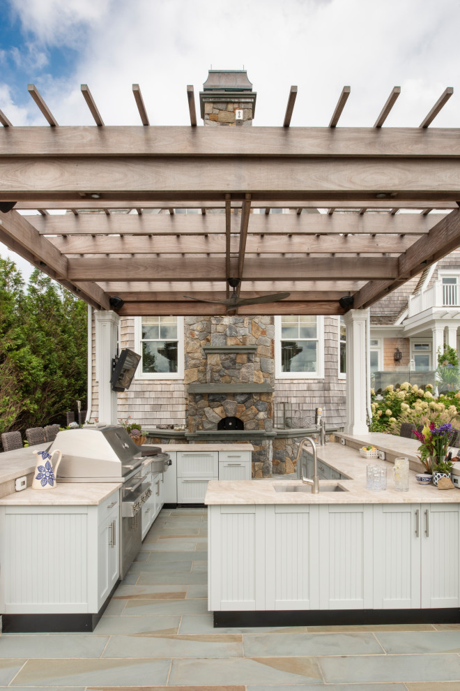 Inspiration for a coastal patio in New York with an outdoor kitchen, tiled flooring and a pergola.