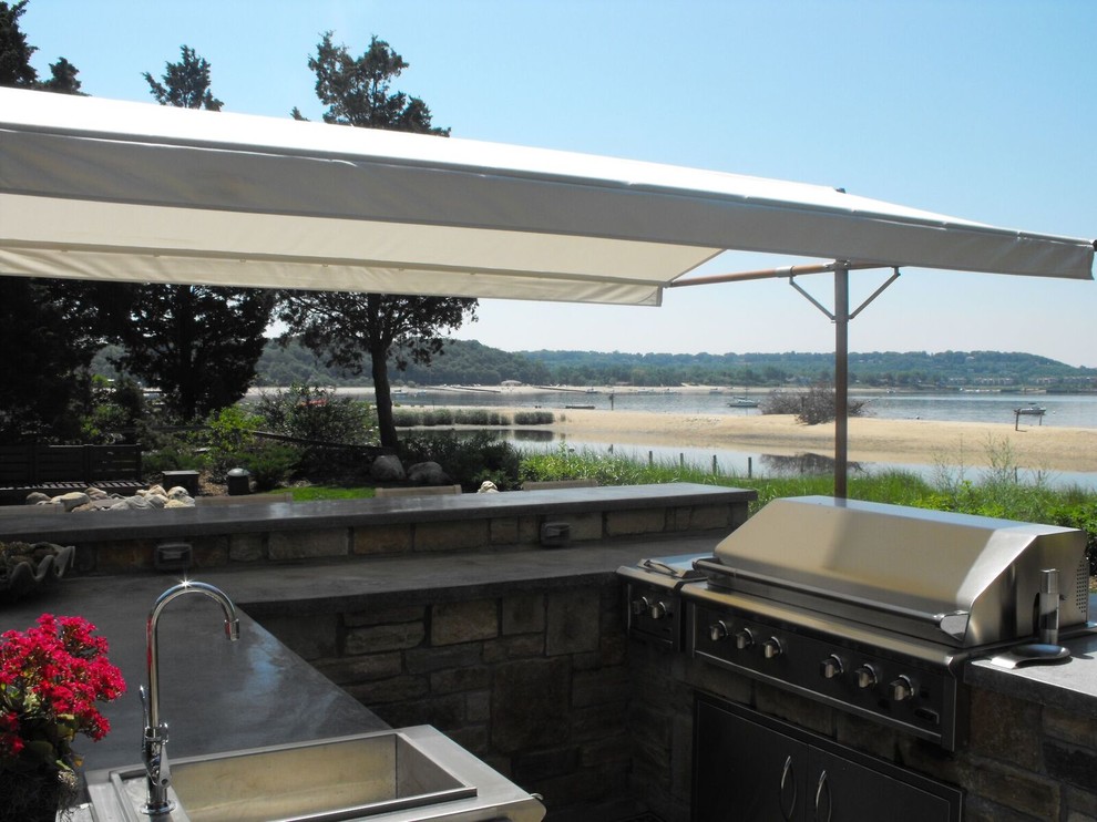 Cette image montre une terrasse arrière traditionnelle de taille moyenne avec une cuisine d'été et un auvent.