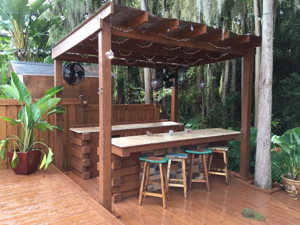 Idee per un patio o portico tropicale di medie dimensioni e dietro casa con pedane e una pergola