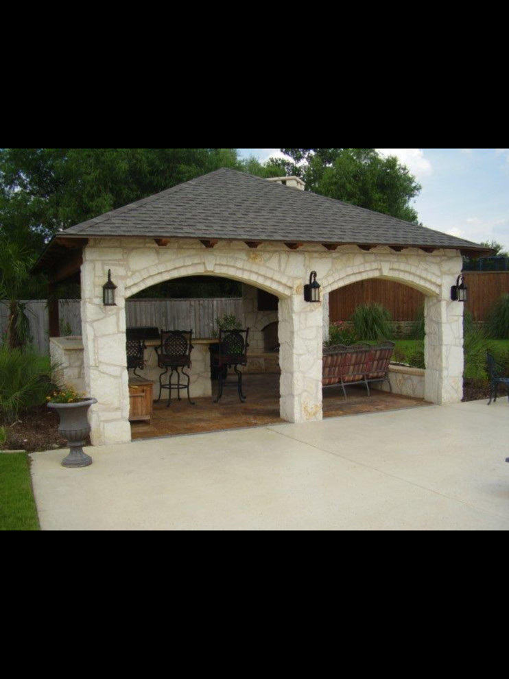 Foto di un patio o portico tradizionale di medie dimensioni e dietro casa con cemento stampato e un gazebo o capanno
