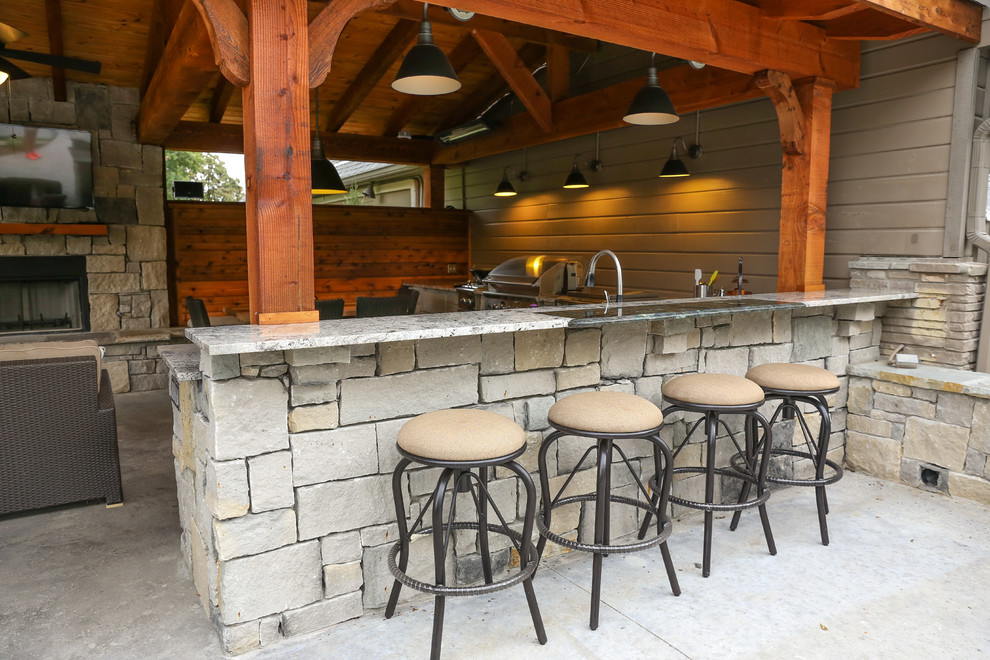 Inspiration for a large rustic backyard concrete patio kitchen remodel in Other with a pergola