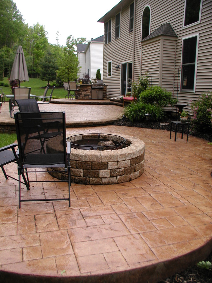 Trendy backyard stamped concrete patio kitchen photo in Cleveland