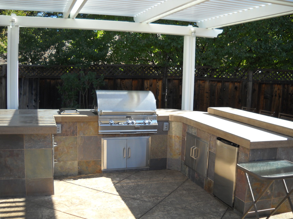 Photo of a large contemporary back patio in San Francisco with an outdoor kitchen, concrete slabs and a pergola.