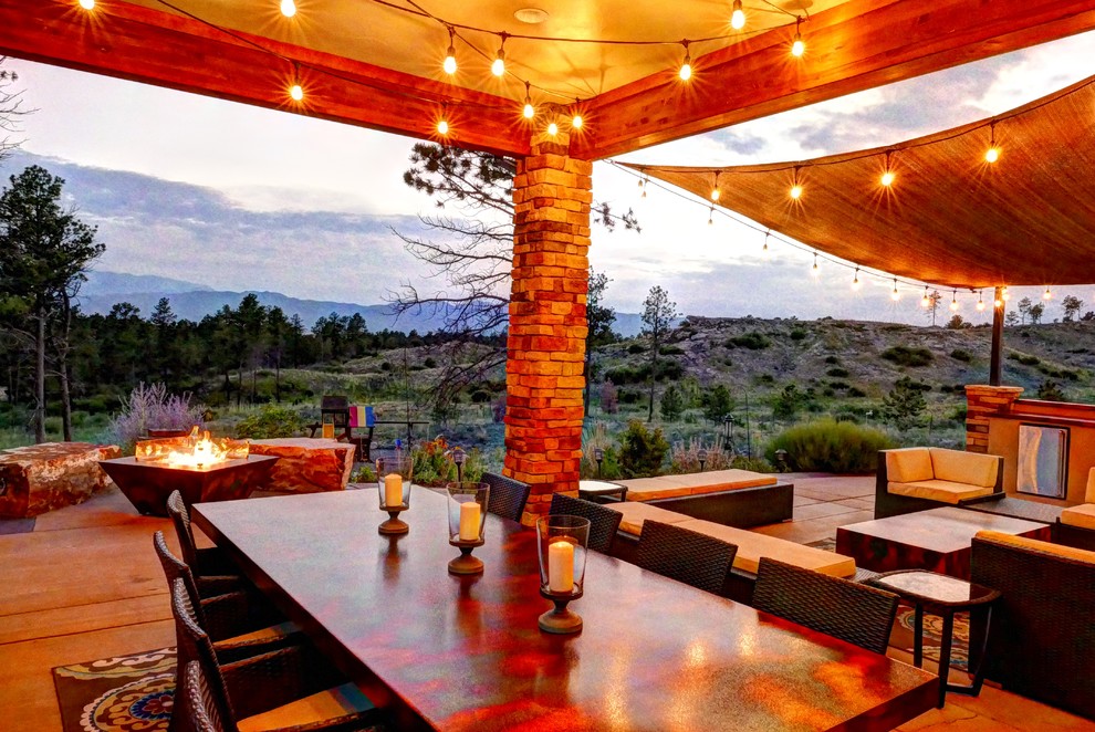 Design ideas for a large eclectic back patio in Denver with an outdoor kitchen, concrete slabs and an awning.