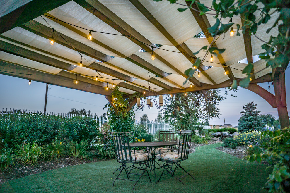 Photo of a large rural back patio in Denver with a pergola.