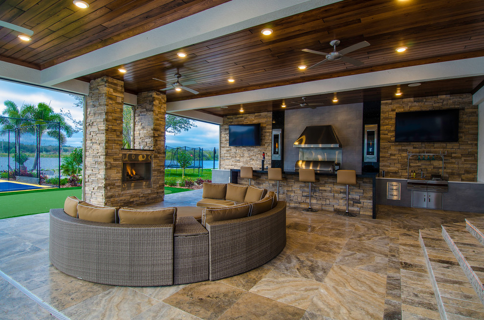 Huge trendy backyard stone patio photo in Tampa with a roof extension