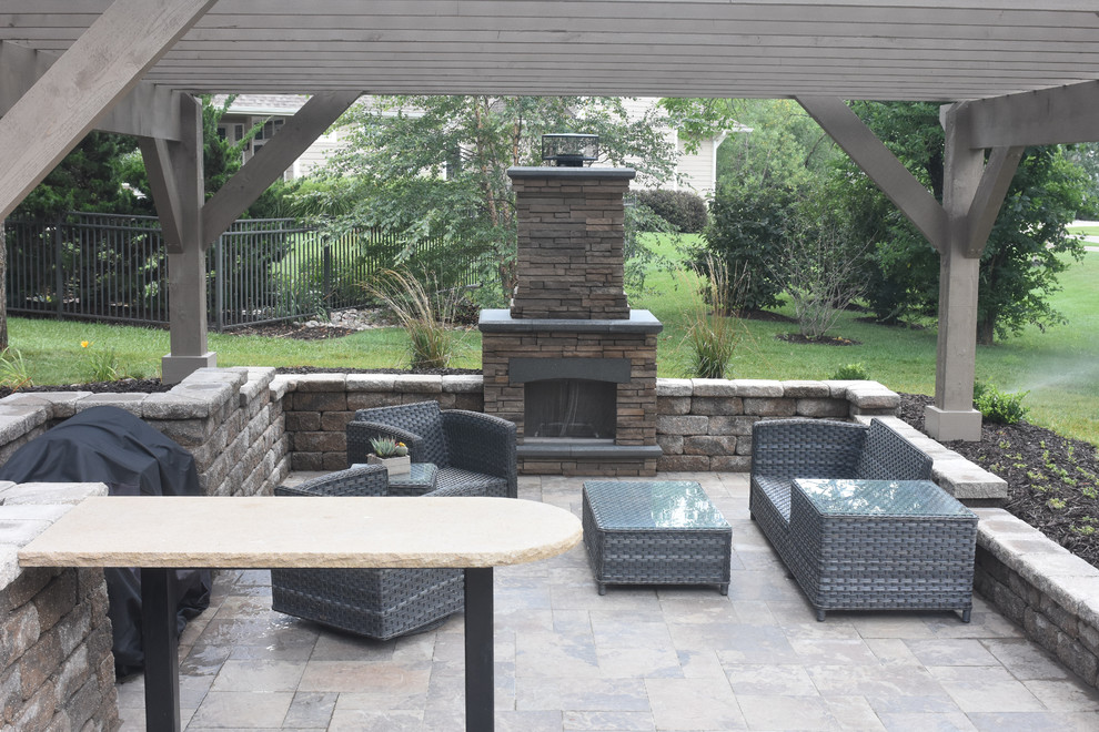 This is an example of a contemporary back patio in Other with a fire feature, concrete paving and a pergola.