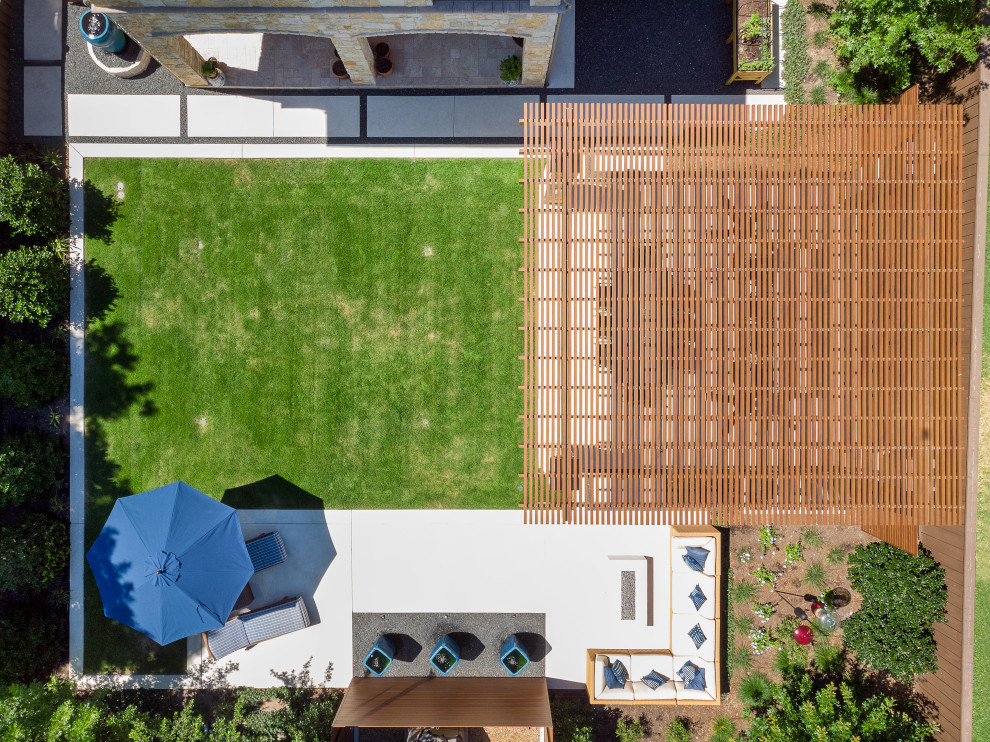 Esempio di un patio o portico minimalista di medie dimensioni e dietro casa con lastre di cemento e una pergola
