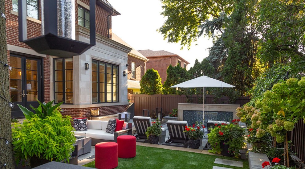 This is an example of a medium sized contemporary back patio in Toronto with a fire feature, concrete paving and no cover.