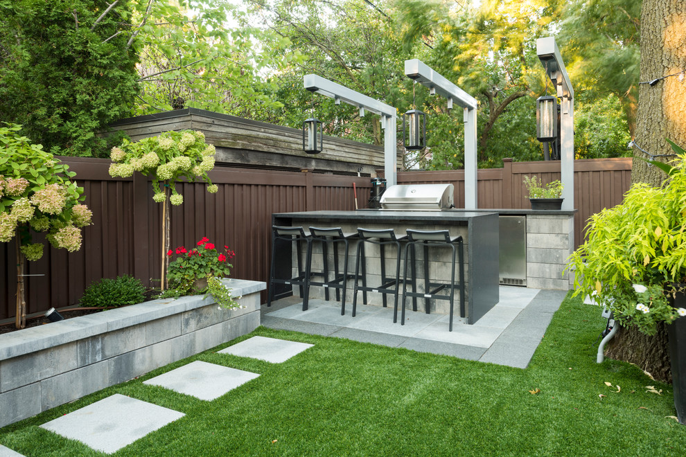 Cette image montre une terrasse arrière design de taille moyenne avec des pavés en béton, aucune couverture et une cuisine d'été.
