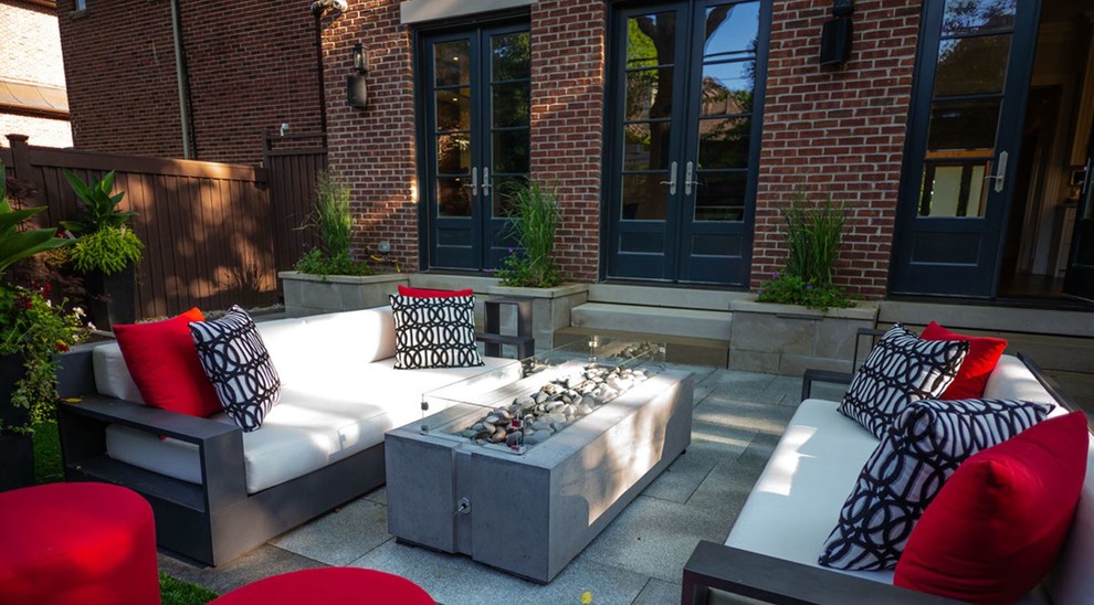 Foto de patio contemporáneo de tamaño medio sin cubierta en patio trasero con brasero y adoquines de hormigón