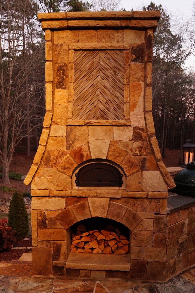 Geräumiger, Unbedeckter Uriger Patio hinter dem Haus mit Feuerstelle und Natursteinplatten in Atlanta