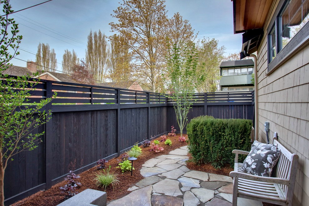Arts and crafts side yard stone patio photo in Seattle
