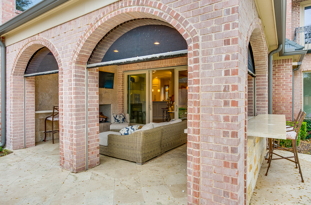 Immagine di un grande patio o portico contemporaneo dietro casa con un focolare, pavimentazioni in pietra naturale e un tetto a sbalzo