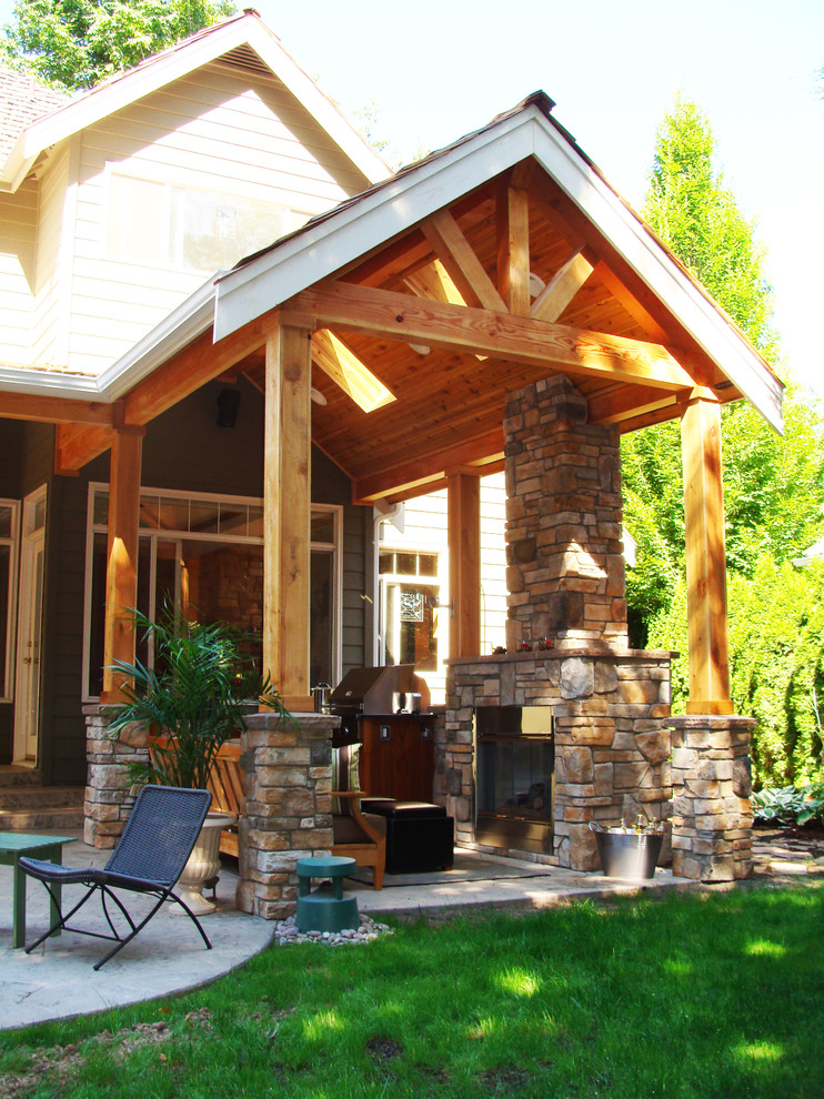 Aménagement d'une terrasse arrière craftsman de taille moyenne avec une cuisine d'été, du béton estampé et une extension de toiture.