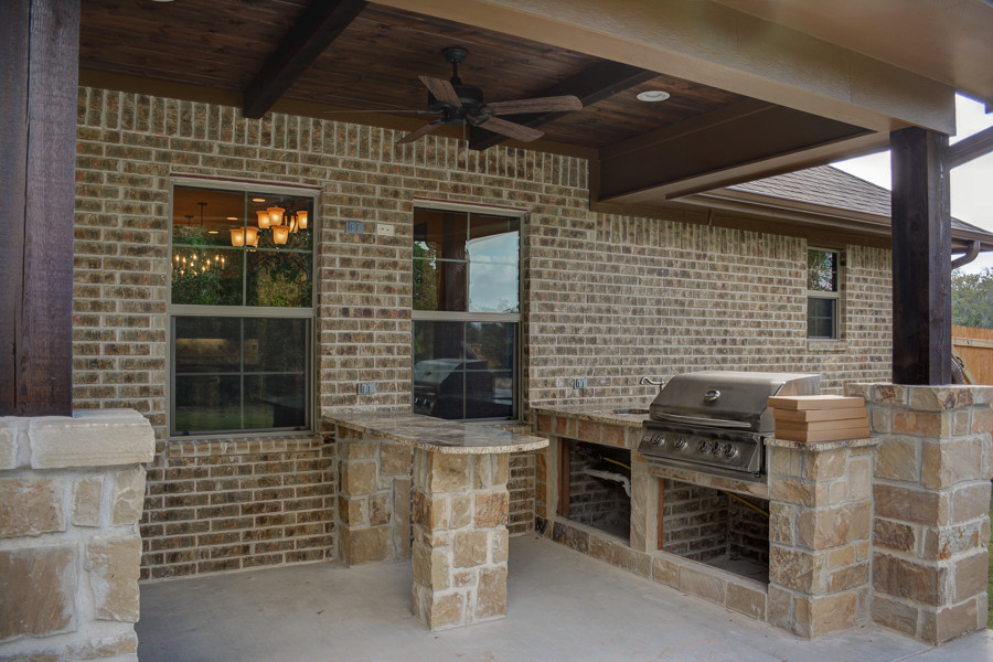 Esempio di un patio o portico rustico di medie dimensioni e dietro casa con lastre di cemento e un tetto a sbalzo