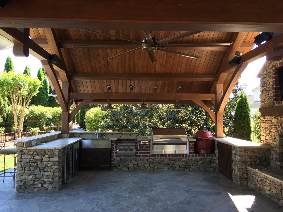 Cette photo montre une grande terrasse arrière moderne avec une cuisine d'été, des pavés en béton et un gazebo ou pavillon.