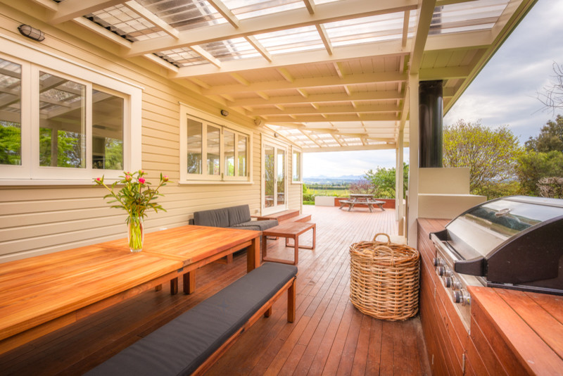 Idée de décoration pour une terrasse en bois design avec un foyer extérieur et une extension de toiture.