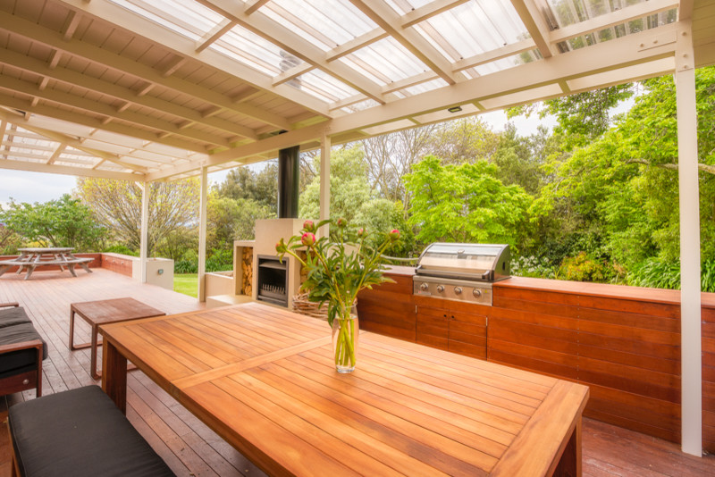 Inspiration pour une terrasse en bois design avec un foyer extérieur et une extension de toiture.