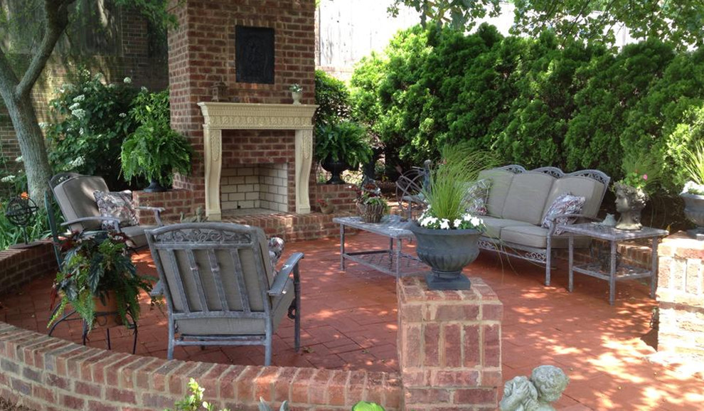 Imagen de patio clásico de tamaño medio sin cubierta en patio trasero con brasero y adoquines de ladrillo