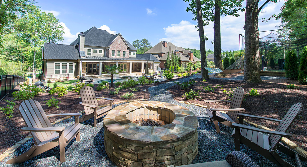 Example of a huge classic backyard gravel patio design in Atlanta with a fire pit and no cover