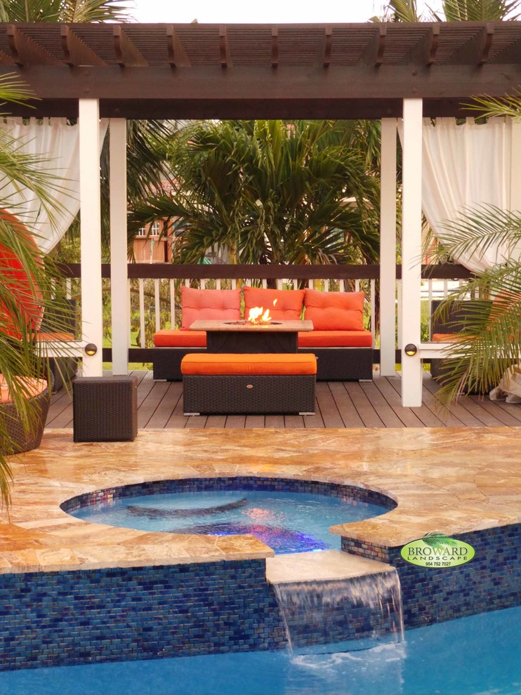 Klassische Pergola hinter dem Haus mit Feuerstelle und Natursteinplatten in Miami