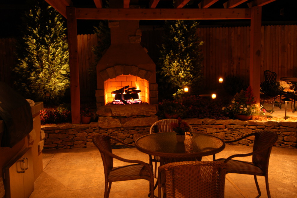 Imagen de patio clásico de tamaño medio sin cubierta en patio trasero con brasero y adoquines de piedra natural