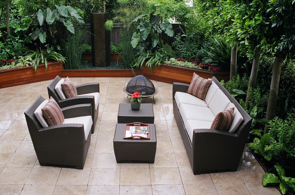 Immagine di un patio o portico tropicale di medie dimensioni e dietro casa con un giardino in vaso, piastrelle e nessuna copertura