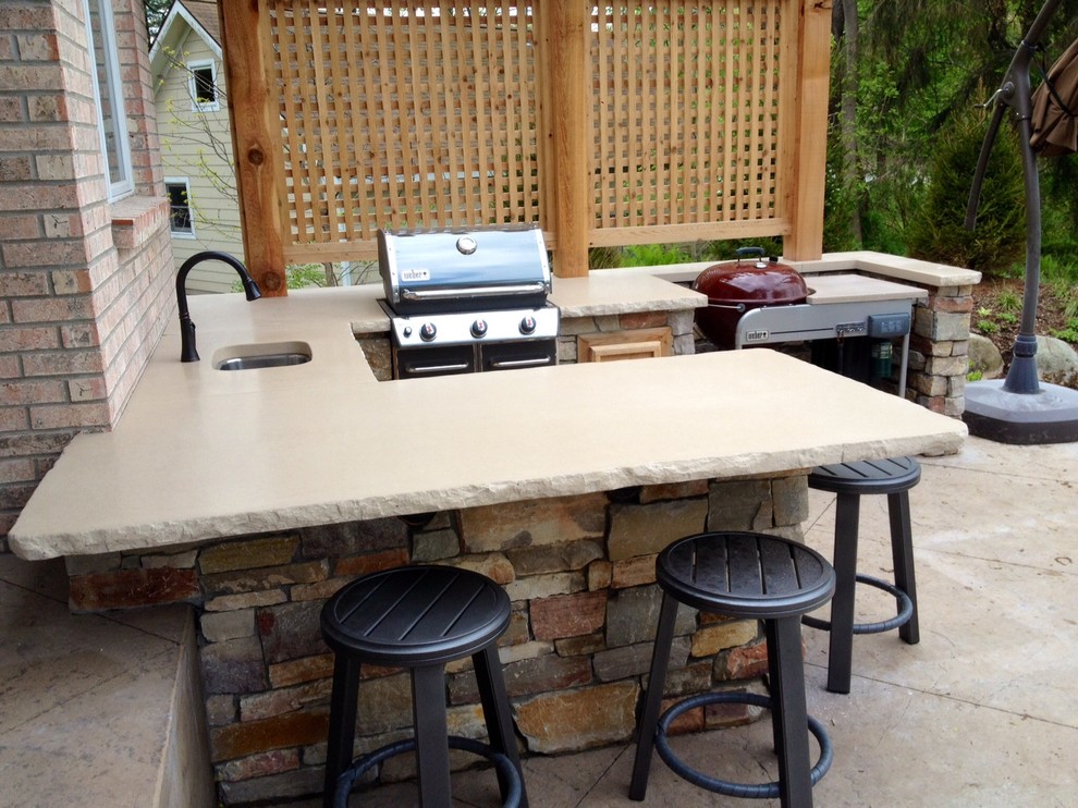 Photo of a traditional back patio in Grand Rapids with an outdoor kitchen, stamped concrete and a gazebo.