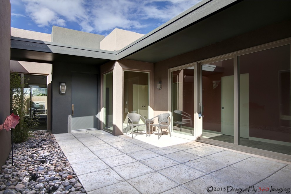 Inspiration for a large contemporary courtyard patio in Albuquerque with a water feature, stamped concrete and a roof extension.