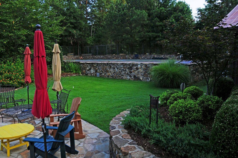 На фото: большой двор на заднем дворе в современном стиле с покрытием из каменной брусчатки без защиты от солнца с