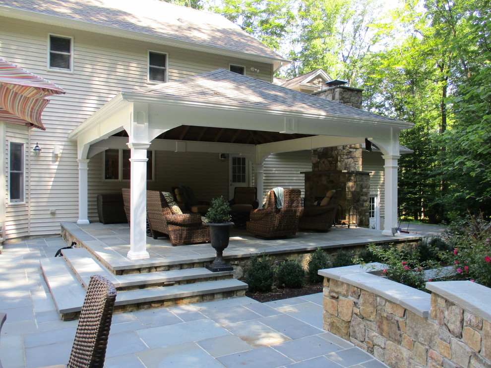 Modelo de patio clásico grande en patio trasero con adoquines de piedra natural y pérgola
