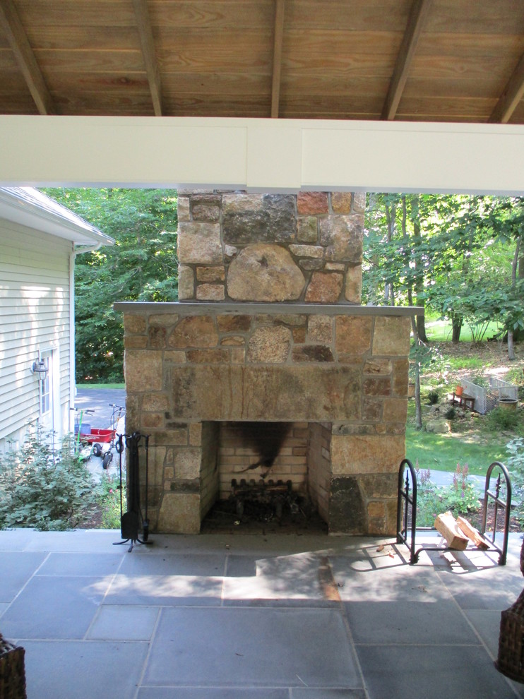 Example of a large classic backyard stone patio design in New York with a pergola